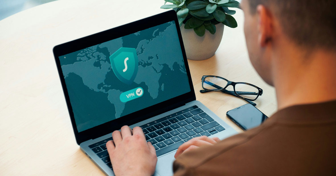 Un utilisateur configure un VPN sur son ordinateur portable, avec des lunettes et un téléphone à côté.